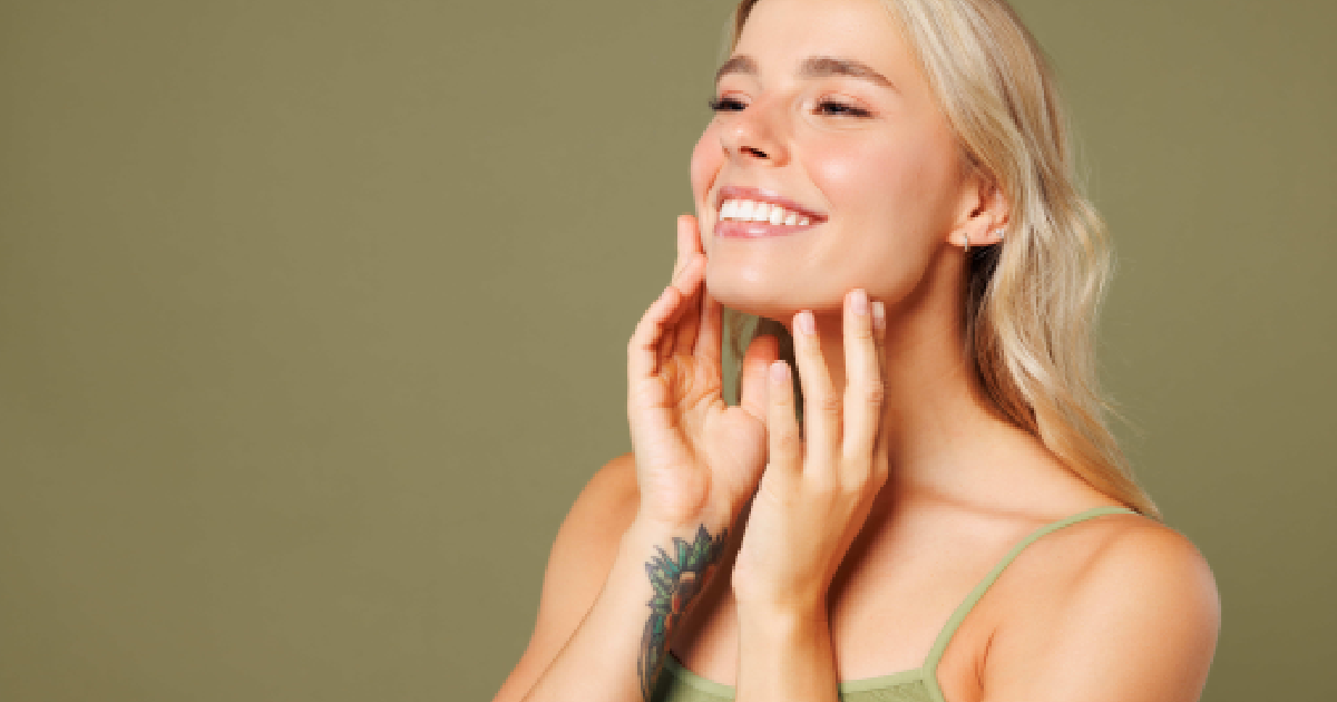Smiling woman touches jawline and cheek after Sculptra treatment in Oak Brook Terrace, Illinois